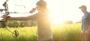 Chase Burns of LandGuys with his son and bow on their homesteading farm in Western Illinois